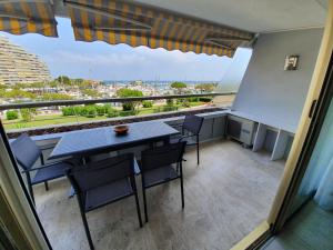 a balcony with a table and chairs and a view at Sun Marina Baie in Villeneuve-Loubet