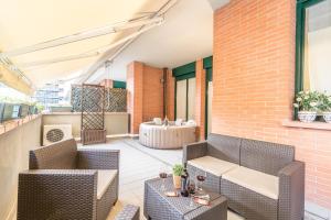 un patio al aire libre con sillas de mimbre y una mesa en 4 Star Family & Friends Apt - Self Check-in, en Bolonia
