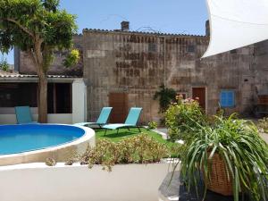 un patio trasero con piscina, sillas y plantas en Sa Lluna Blava, en Santa Margalida