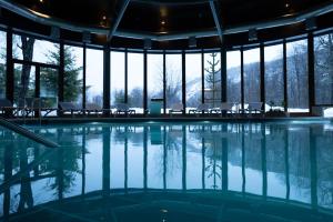 a swimming pool in a building with a view of the mountains at Hotel Termas Chillán in Nevados de Chillan