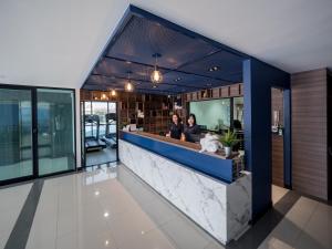 two people sitting at a counter in a building at Tassana Place in Chon Buri