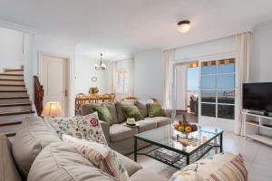 a living room with a couch and a tv at VILLA ATLANTIC view with JACUZZI in Adeje