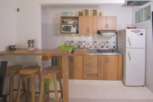a kitchen with a counter with stools and a refrigerator at Cabaña Coveñitas 2 in Coveñas