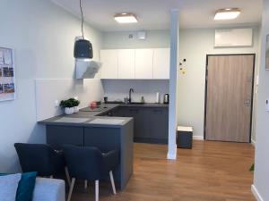 a kitchen with blue cabinets and a table and chairs at Apartament Smart in Szczecin