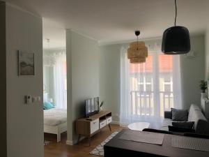 ein Wohnzimmer mit einem Sofa und einem TV in der Unterkunft Apartament Smart in Stettin