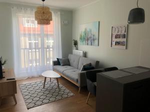 a living room with a couch and a table at Apartament Smart in Szczecin