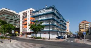 an apartment building with a blue facade on a city street at Sur Suites La Dorada in Fuengirola