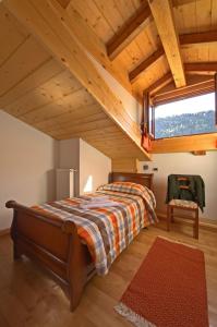 a bedroom with a bed and a large window at Pa' Eimbdlar in Sauris
