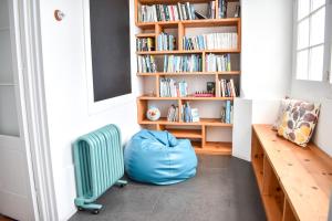 una habitación con una bolsa azul y un estante de libros en A Casa da Cascata en Ribeira Grande