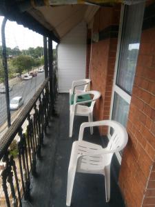 two white chairs sitting on the porch of a building at THE CHADWICK in Skegness