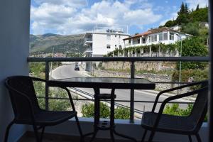 una mesa y sillas en un balcón con vistas a la calle en Velco BB Himara en Himare