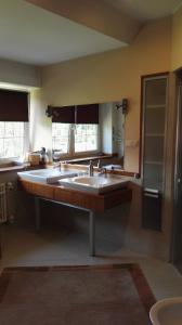 a large bathroom with two sinks and a large mirror at Kaszubiana direkt in der Natur in Sulmin