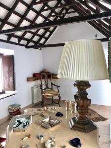 a table with a lamp and a chair in a room at Casa Antigua - Terraza con Vistas al Mar in Medina Sidonia