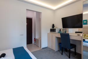 a hotel room with a bed and a desk with a television at MBM Studio Piata Romana Square in Bucharest