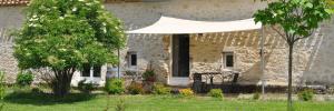 a white tent in front of a stone house at Les Gonies - Cyprès in Mauroux