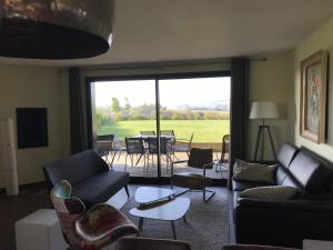 a living room with a couch and chairs and a patio at Coolcottage des 2 Caps in Leulinghen-Bernes