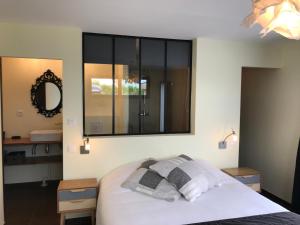 1 dormitorio con 1 cama con 2 almohadas y espejo en Coolcottage des 2 Caps, en Leulinghen-Bernes