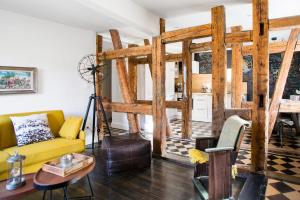 a living room with a yellow couch and a table at Reflets Sur La Lauch appartements in Colmar