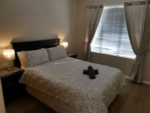 a black cross laying on a bed in a bedroom at Serengeti Self Catering Units in Bellville +25 photos