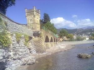 un bâtiment avec une tour d'horloge à côté d'une rivière dans l'établissement Casavacanza " LA CONCHIGLIA ", à Sapri