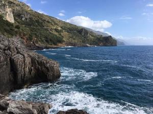 a large body of water next to a rocky mountain at Casavacanza " LA CONCHIGLIA " in Sapri