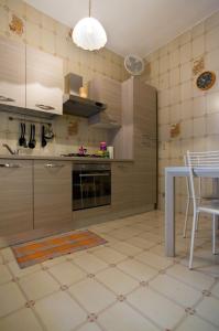 - une cuisine avec des placards en bois, une table et des chaises dans l'établissement Casavacanza " LA CONCHIGLIA ", à Sapri