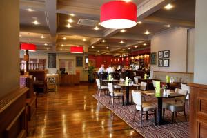 a restaurant with tables and chairs and a bar at Great National Hotel Ballina in Ballina