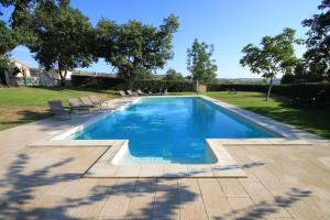 a swimming pool with chairs in a yard at Agriturismo Rosso di Sera in Cugnoli