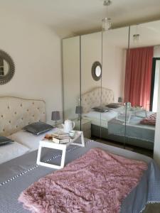 a bedroom with two beds and a mirror at Baltic Park Kryształowy apartament in Pogorzelica