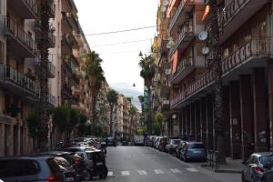 una strada cittadina con auto parcheggiate sui lati di Mare di Luci a Salerno