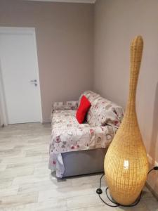 Schlafzimmer mit einem Bett mit einem roten Kissen und einer Vase in der Unterkunft La casa di Beppe c cir D1135 in Lanzo dʼIntelvi