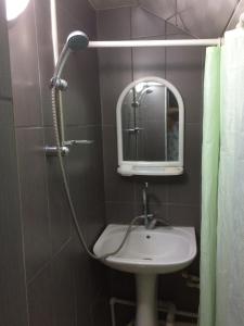 y baño con lavabo y ducha con espejo. en Alex's Cosy Guesthouse, en Tiflis
