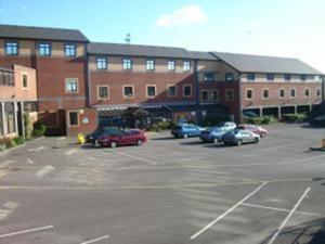 un estacionamiento con autos estacionados frente a un edificio en The Birmingham Hotel, en Birmingham