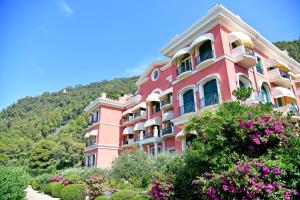 een roze gebouw met bloemen ervoor bij A.A.U.T Appartamento Villa Preli (codiceCITRA 010015-LT-0013) in Chiavari