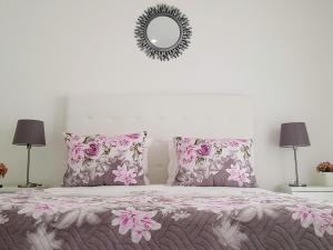 una camera da letto con letto, cuscini rosa e specchio di Old Dream a Nazaré