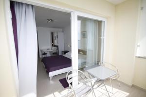 a room with a bed and a chair and a mirror at Pension Villa Rosa in Rtina