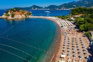 an aerial view of a beach with chairs and umbrellas at Hotel California by Aycon in Sveti Stefan