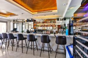 a bar with black stools in a room at Hotel California by Aycon in Sveti Stefan