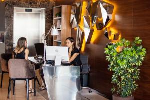 two women sitting at a desk with a laptop at Hotel California by Aycon in Sveti Stefan