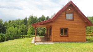 una pequeña casa de madera con un porche en un campo en Dom nad doliną Sanu, en Ruszelczyce