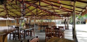 a restaurant with wooden tables and chairs and a fence at Buenavista Family Inn in Tagudin