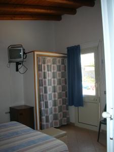 1 dormitorio con 1 cama y TV en la pared en B&B Caserta, en Ustica