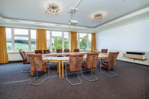 une salle de conférence avec une grande table et des chaises dans l'établissement Landhotel Buller, à Hagen