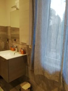 a bathroom with a sink and a shower curtain at La casa di Beppe c cir D1135 in Lanzo dʼIntelvi