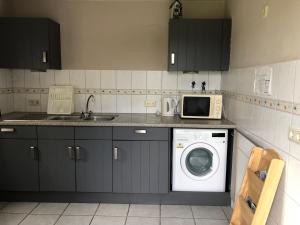 a kitchen with a washing machine and a microwave at Trekkershut/kampeerhut in Hulst