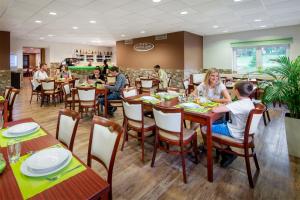 a group of people sitting at tables in a restaurant at Hotel Bon in Tanvald