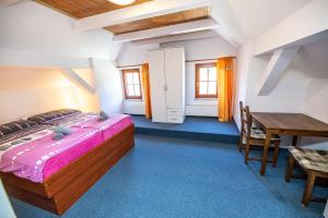 Schlafzimmer mit einem Bett, einem Schreibtisch und einem Tisch in der Unterkunft penzion Hamerská Jizba in Nové Hamry