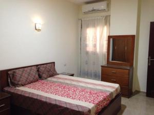 - une chambre avec un lit, une commode et une fenêtre dans l'établissement Hurghada Comfort Apartments, à Hurghada