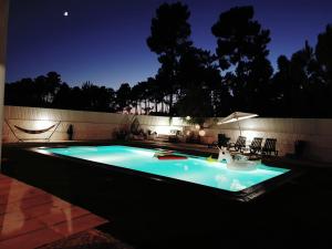 a swimming pool lit up at night at First In in Corroios