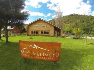 a sign in the grass in front of a building at Alto Melimoyu Hotel & Patagonia in La Junta